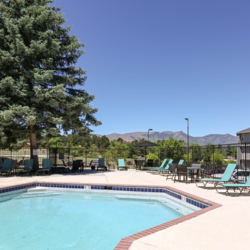 Pool with sundeck facing the mountains and trees