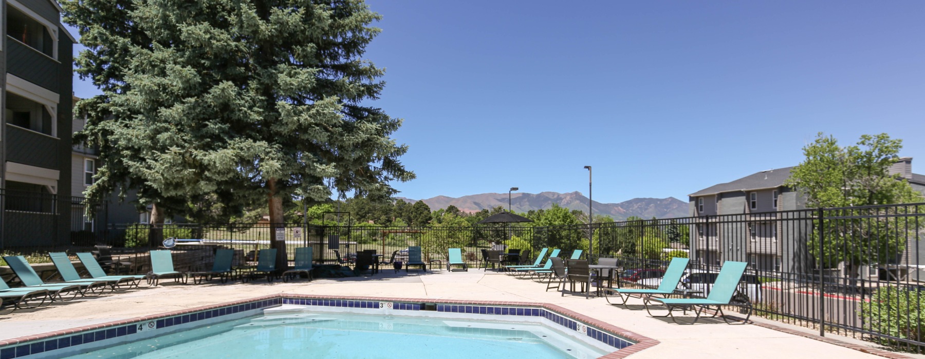 Pool with sundeck facing the mountains and trees